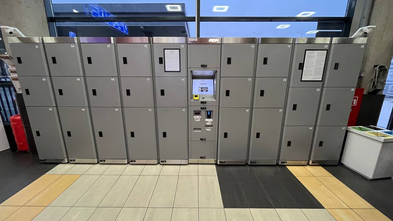 Row of metal luggage lockers with terminal at a railway station