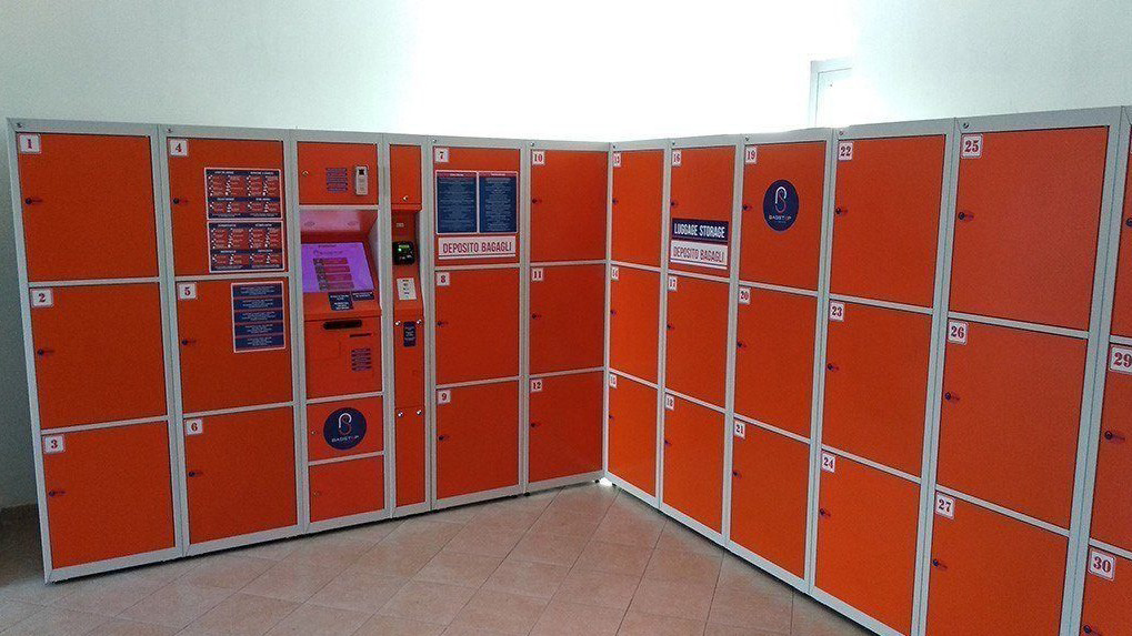Ряды оранжевых ячеек камеры хранения багажа Locker Room в Риме, Италия, 2021 г.